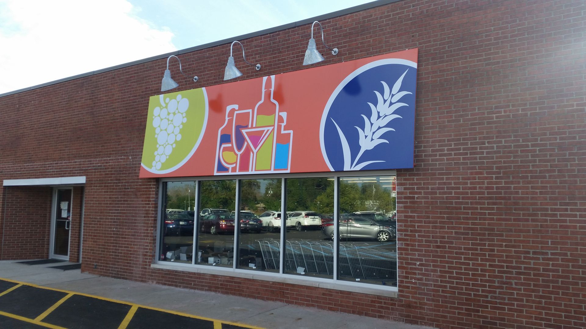 Brick storefront with a colorful grape and wine sign above the windows