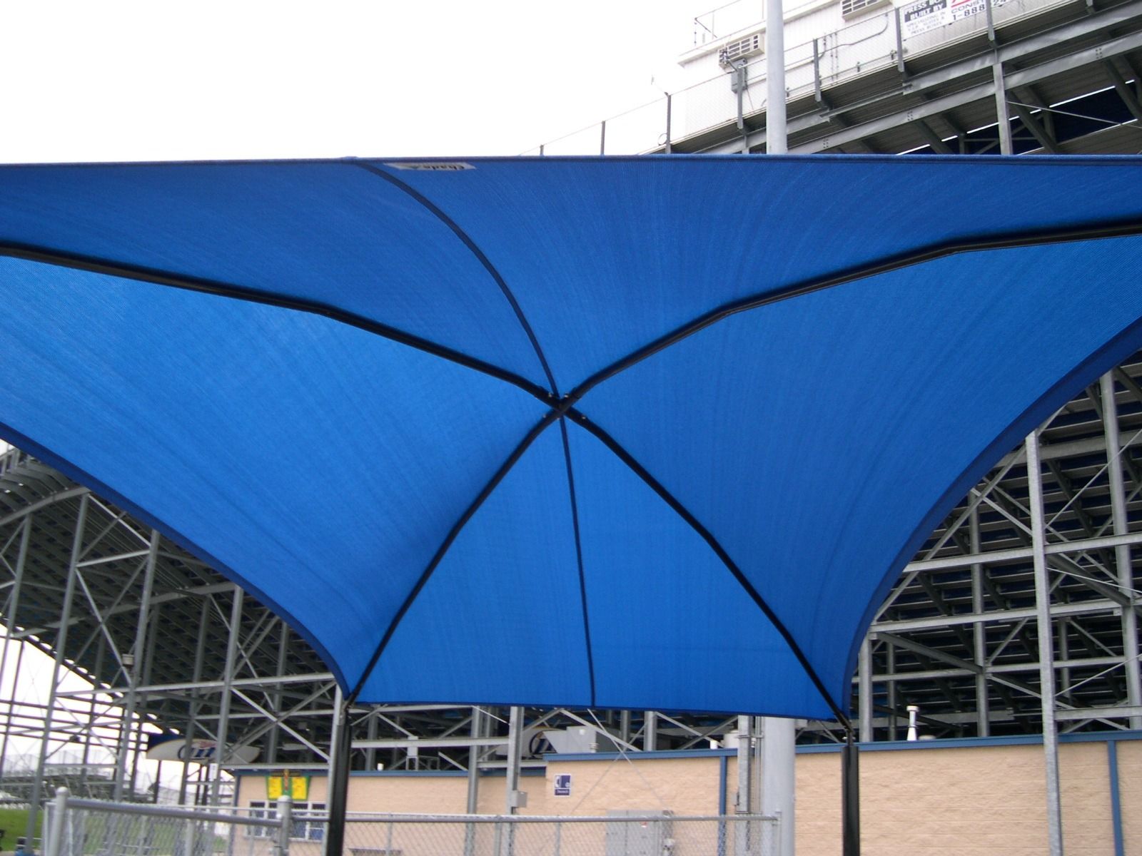Blue tensile canopy under a stadium roof structure