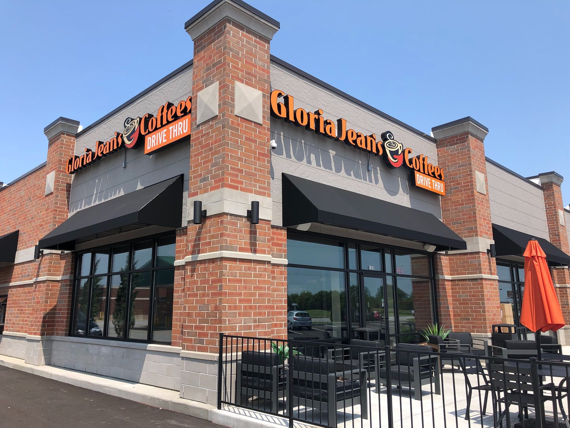 Charlie Redd's Grill restaurant exterior with black awnings and patio seating on a brick corner building