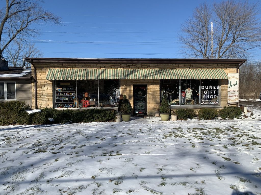 Snowy storefront with striped awning, brick facade, and a sign reading “Funky Town” under a blue sky