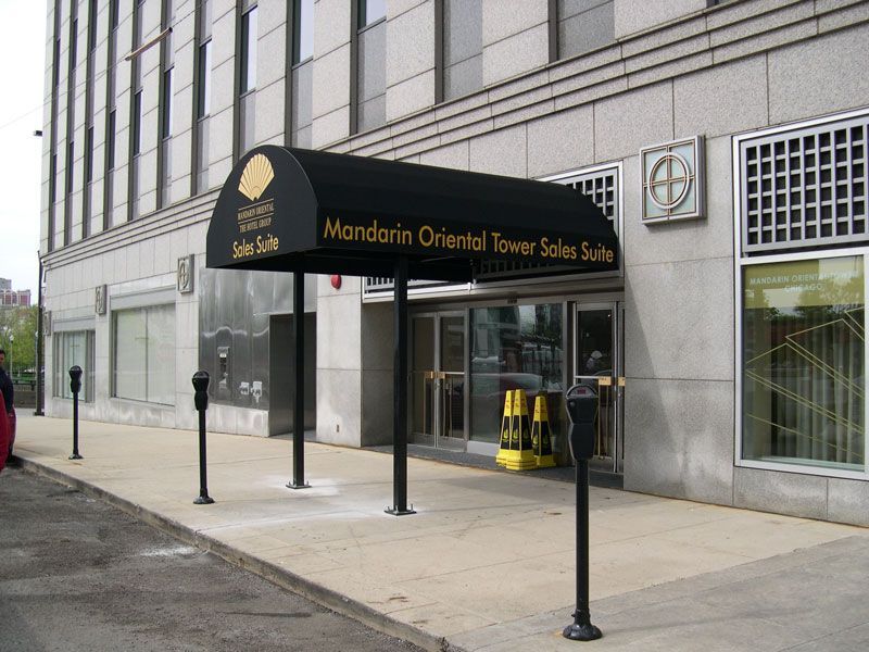 Entrance of the Mandarin Oriental Tower Suites under a black awning on a city sidewalk