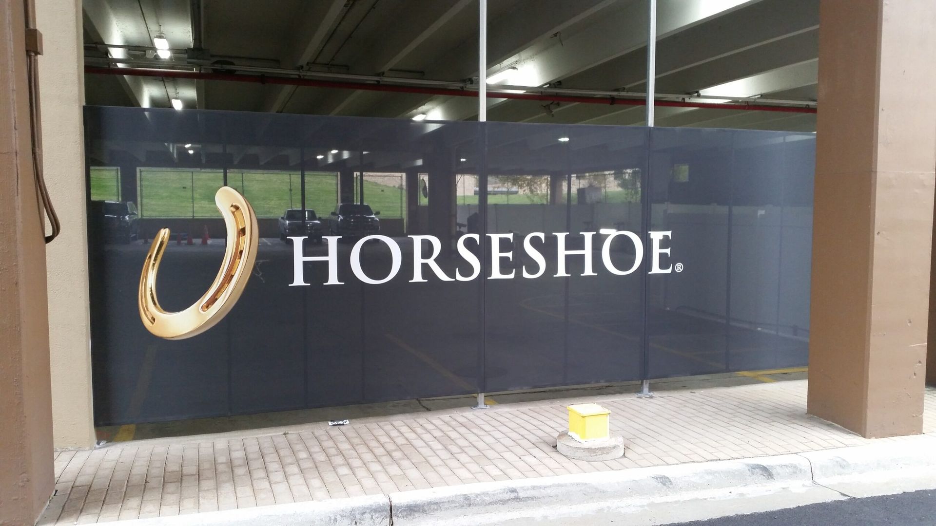 Horseshoe storefront sign on a glass wall under an overhang