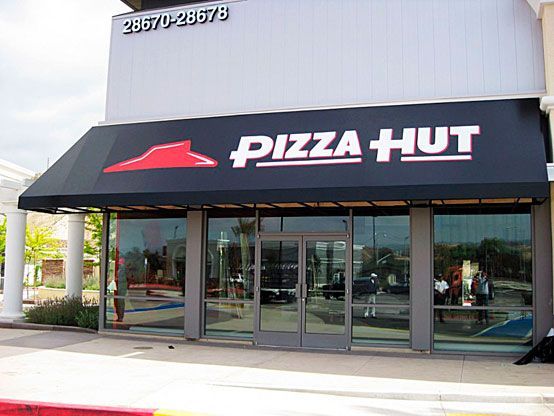 Pizza Hut storefront with black awning and red logo above glass entrance