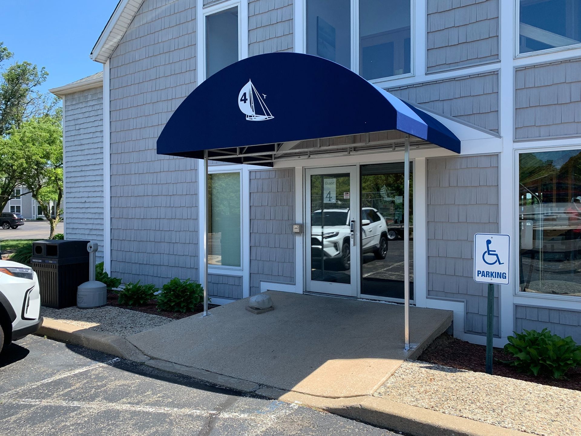 Office entrance with blue awning and wheelchair accessibility sign at the doorway