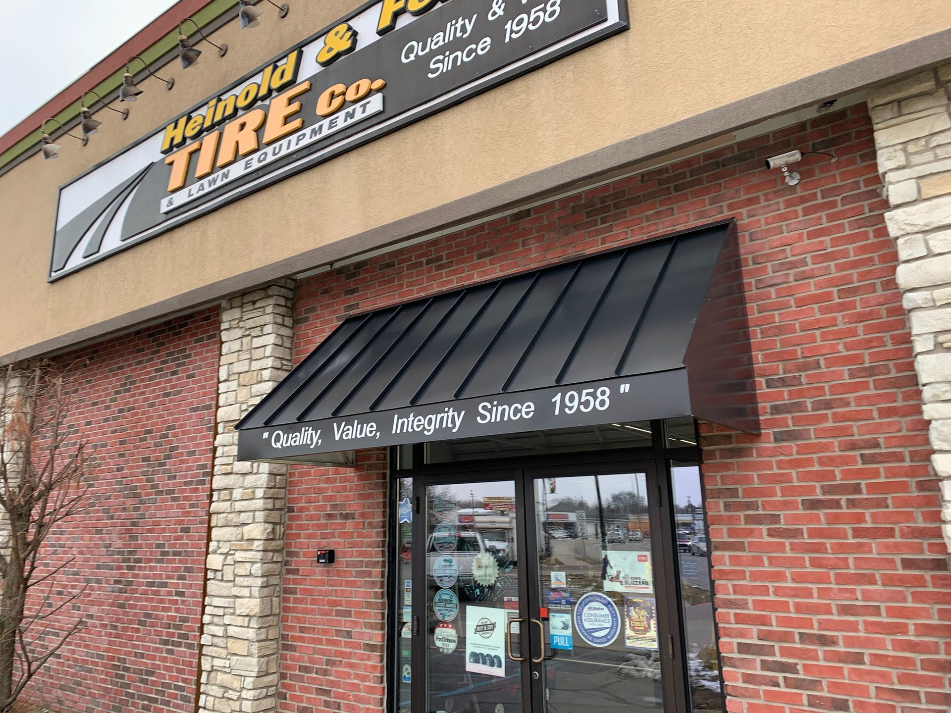 Brick storefront with a black awning and sign for “Hometown Tire Co.”