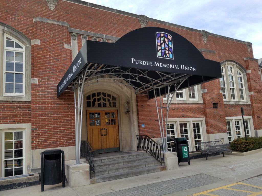 Front entrance of the Family Health Center, a brick building with a black awning and steps leading to double doors