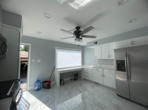 A kitchen with stainless steel appliances and a ceiling fan
