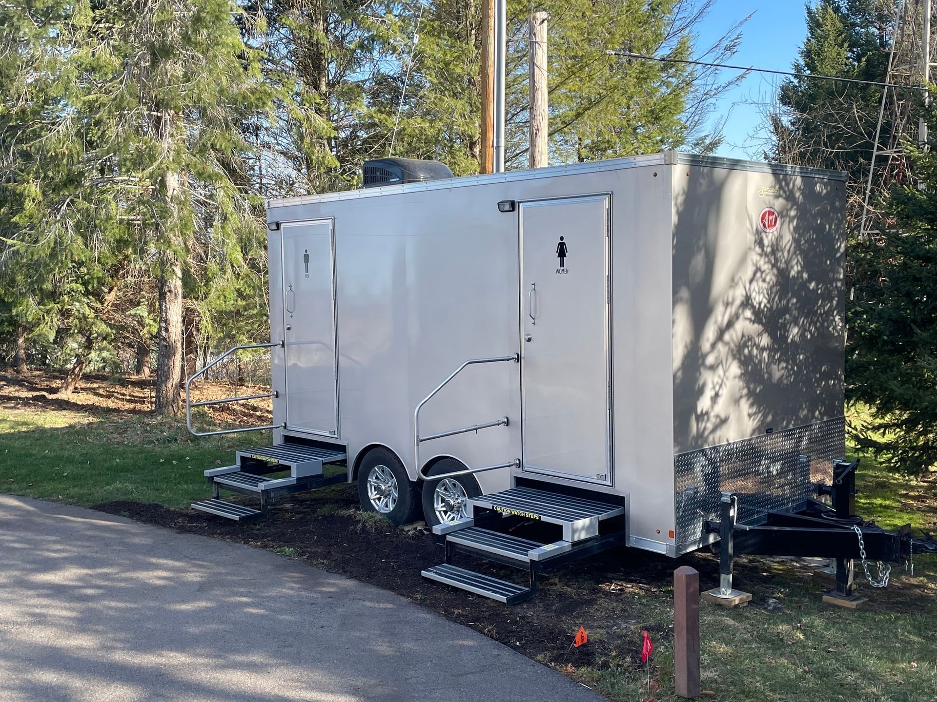 A white trailer is parked on the side of a road.