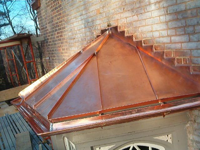 Copper roof on a brick building with a peaked skylight or cupola.