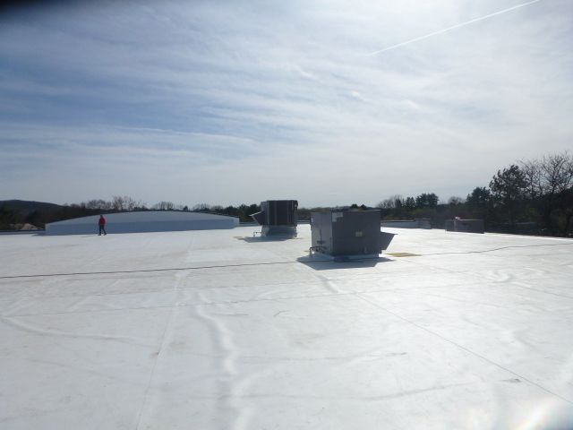 Snow-covered field with two large cylindrical structures under a bright, cloudy sky