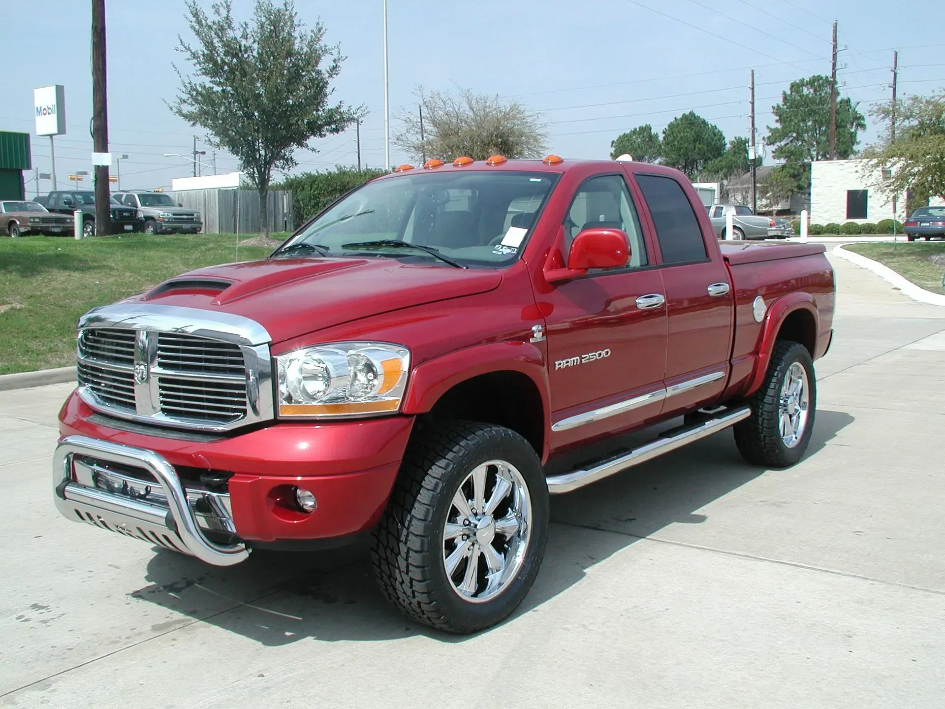 Red Dodge Ram truck with chrome accents, parked outdoors.