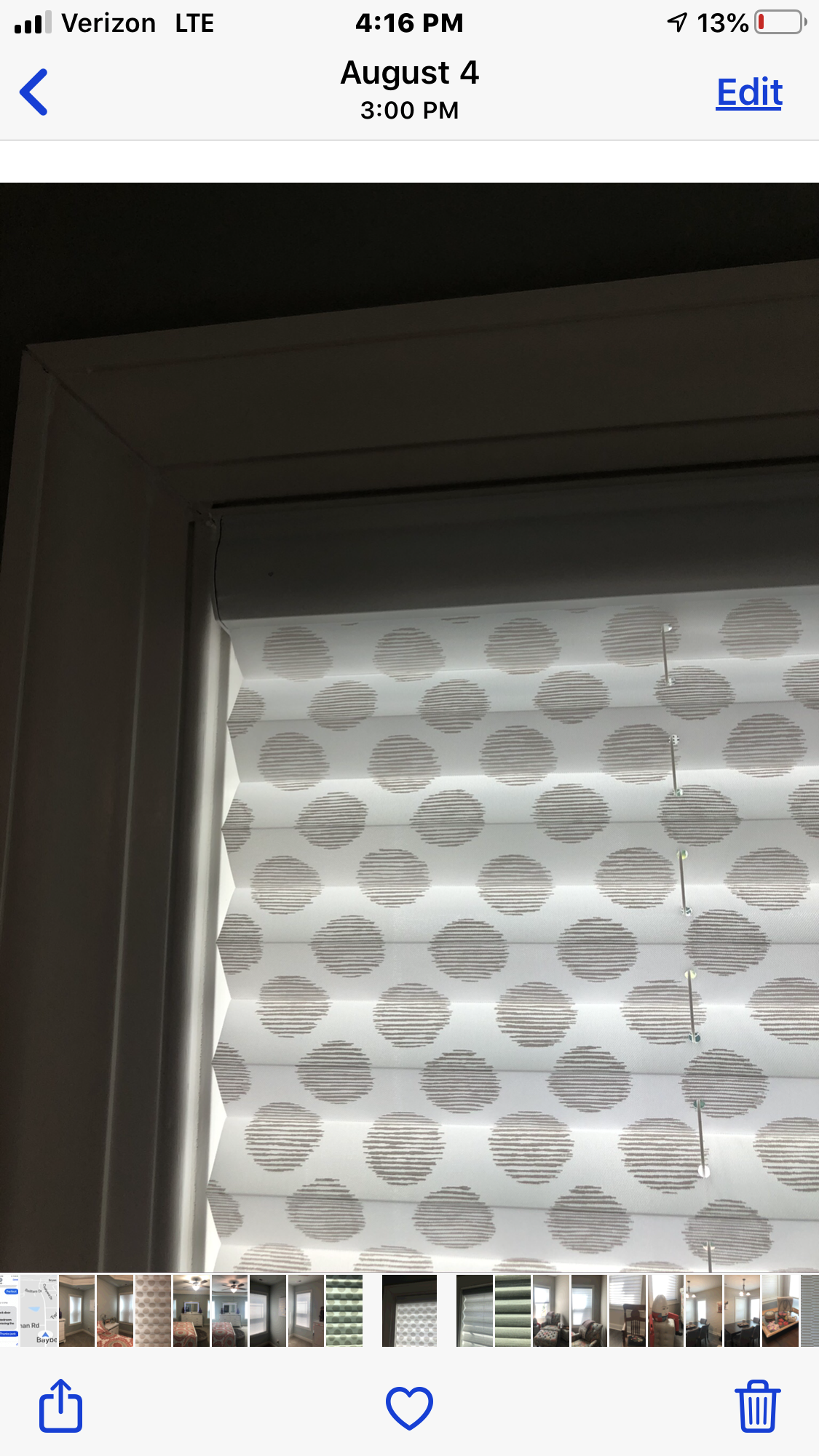 White window shade with gray circle pattern in a white window frame.