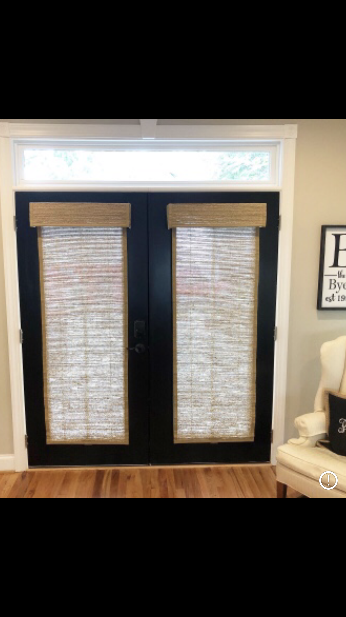 Black French doors with woven shades and white trim.