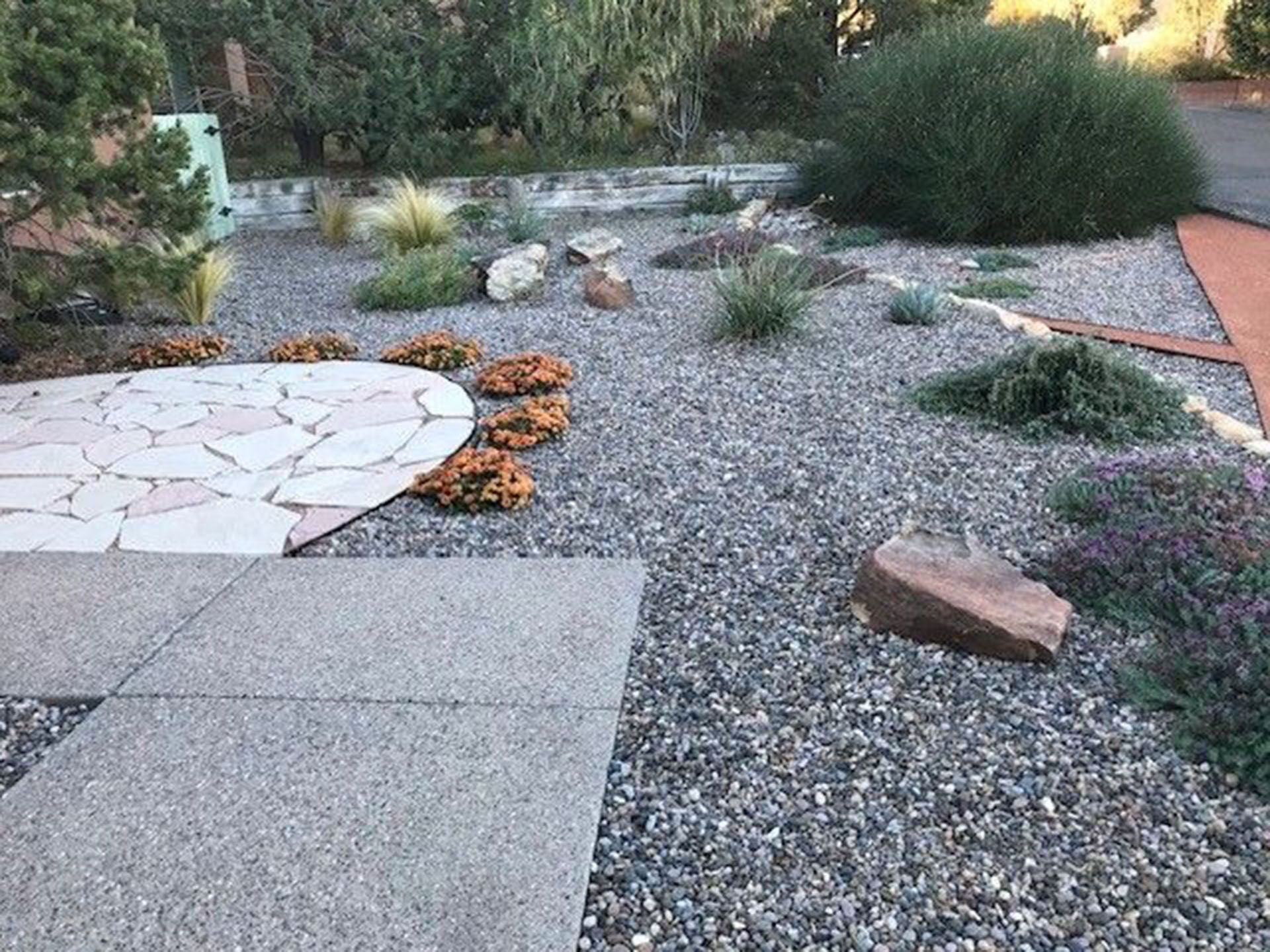 There is a patio in the middle of a gravel garden.