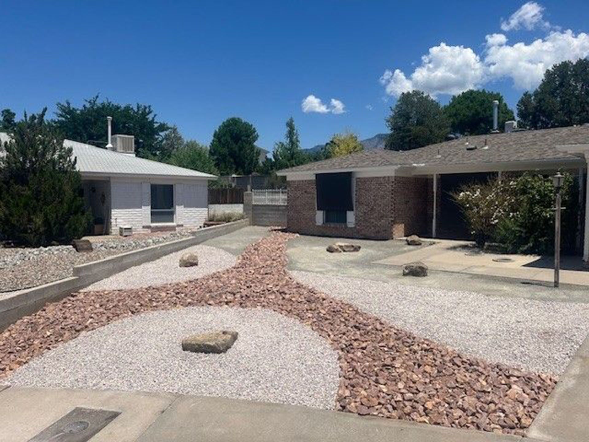 A house with a gravel driveway in front of it.