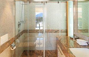 A bathroom with a sliding glass shower door and a sink