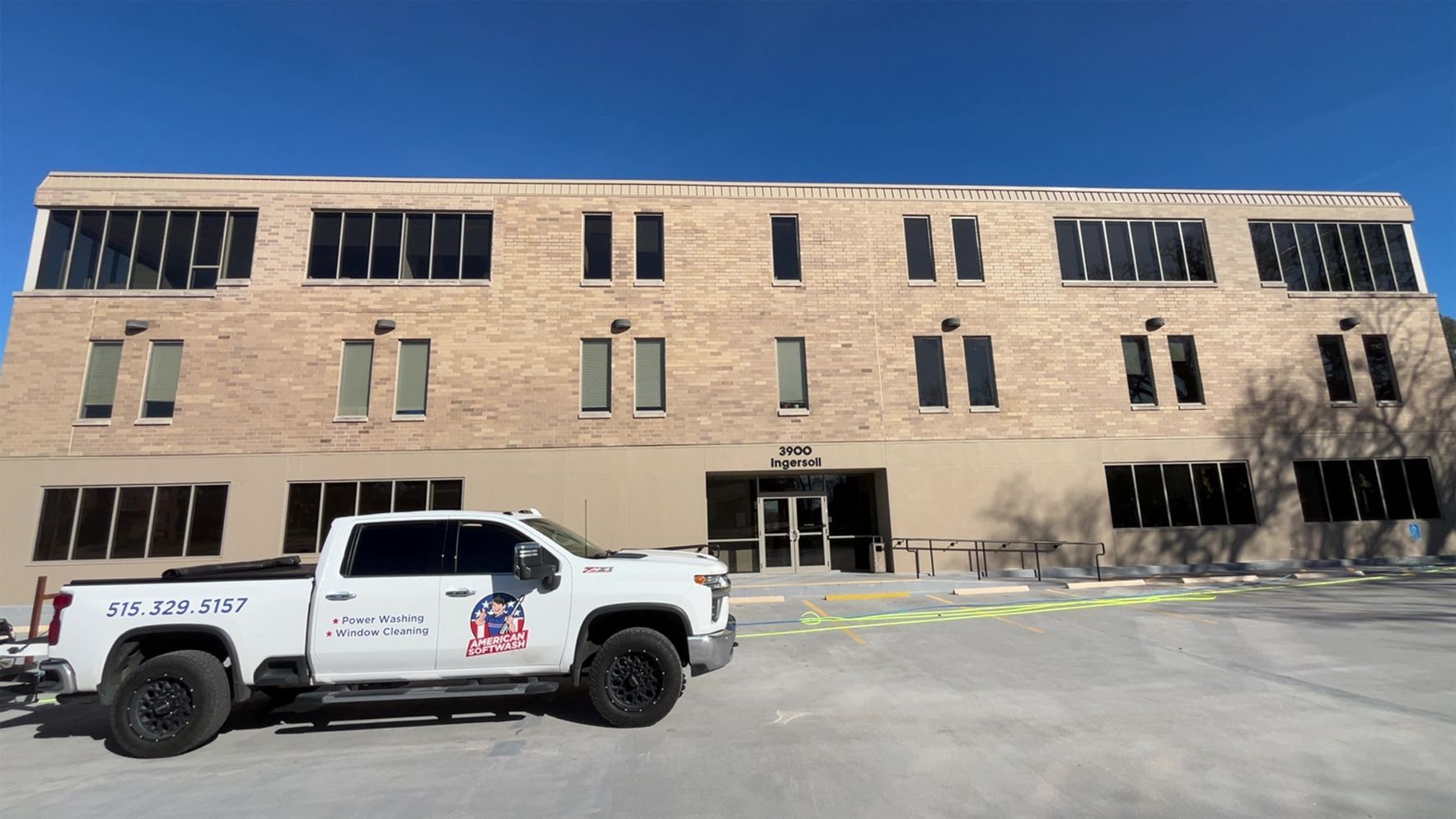 White utility pickup parked in front of a brick building with yellow caution tape across the entrance.