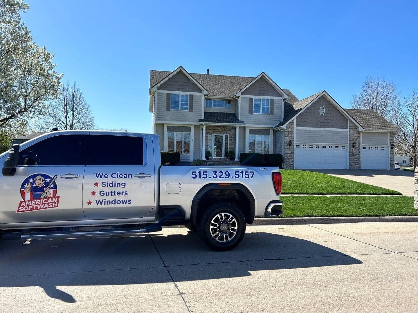 White service truck parked in front of a two-story house on a sunny suburban street