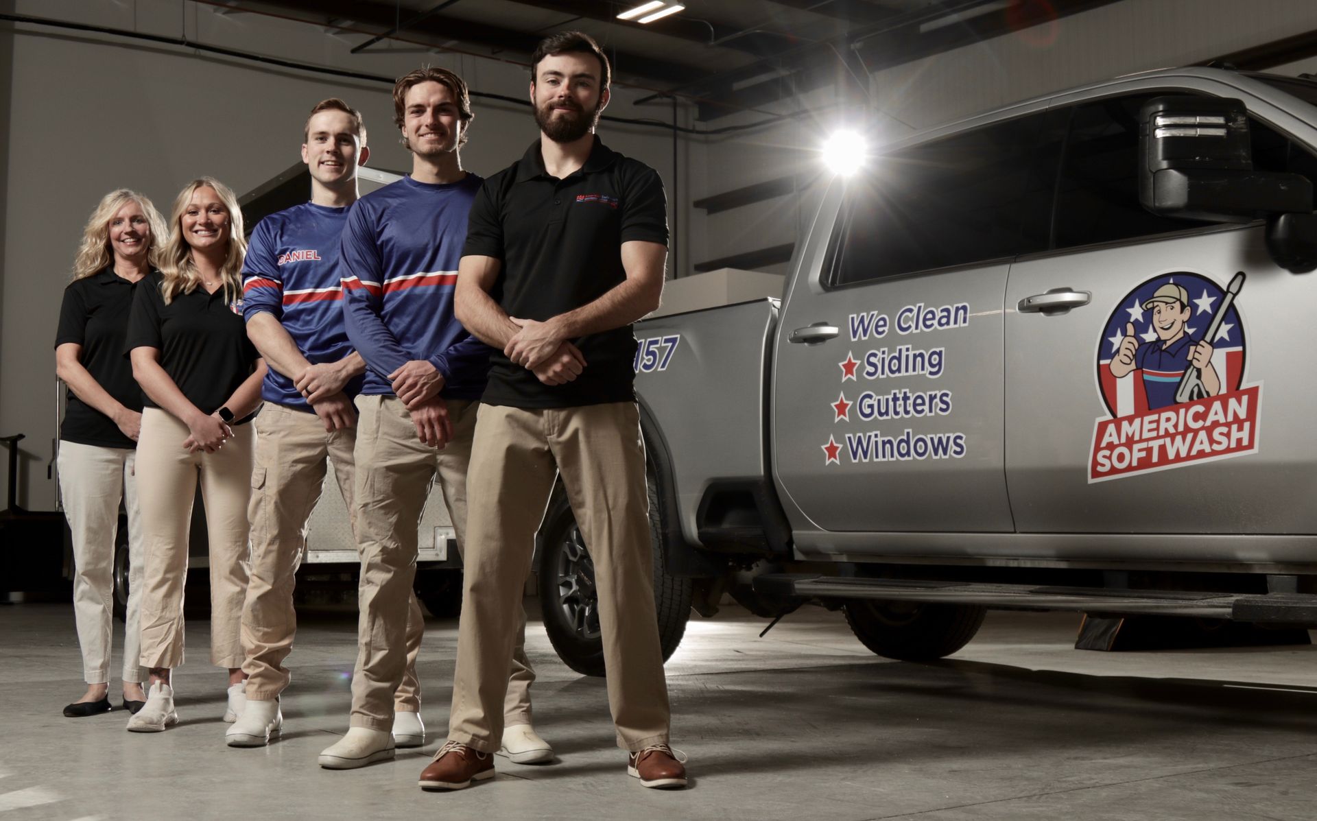 Four people stand beside a van with an “American Red Cross” logo in a parking lot at night.