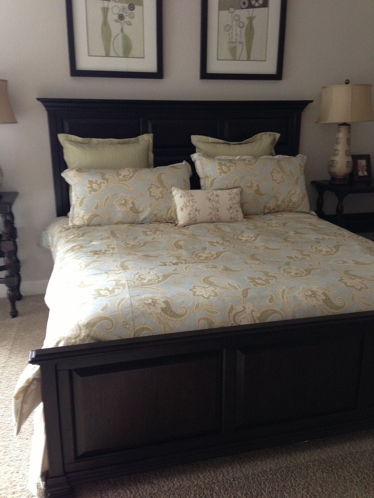 A bedroom with a bed and two pictures on the wall