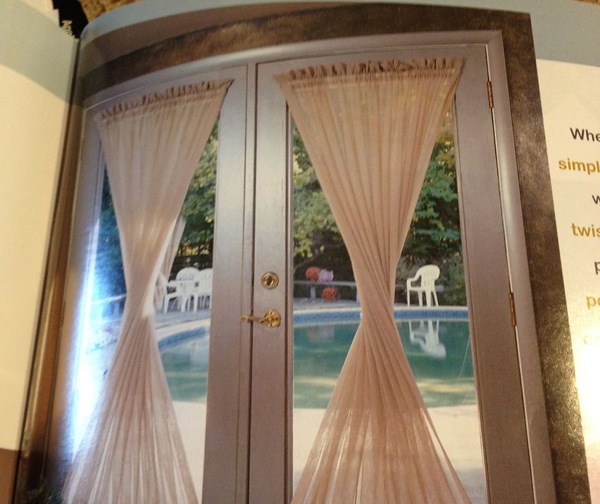 A book is open to a picture of a door with curtains