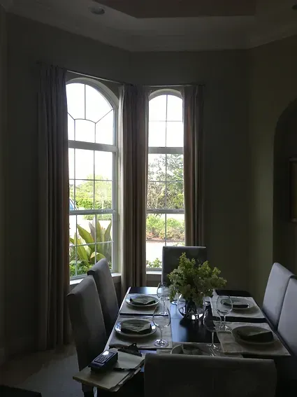 A dining room with a table and chairs and a window.