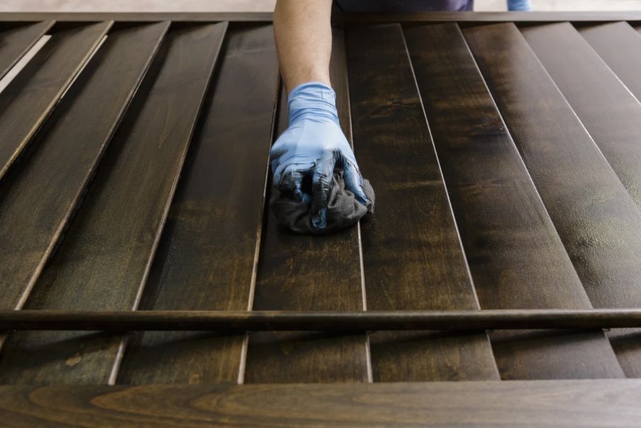 A person is cleaning a wooden surface with a cloth.