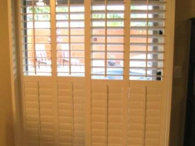 A room with a window and shutters on it.