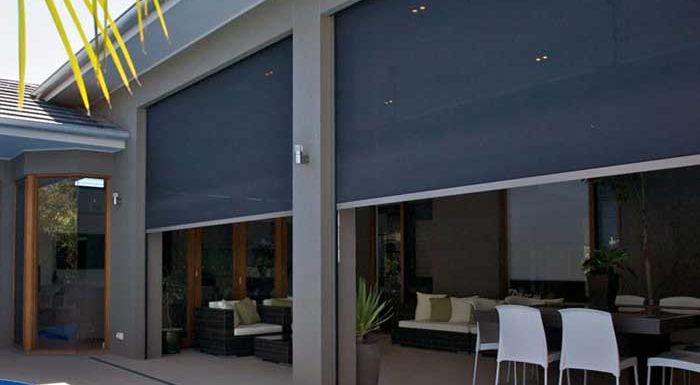 A house with a patio with a table and chairs and a swimming pool.