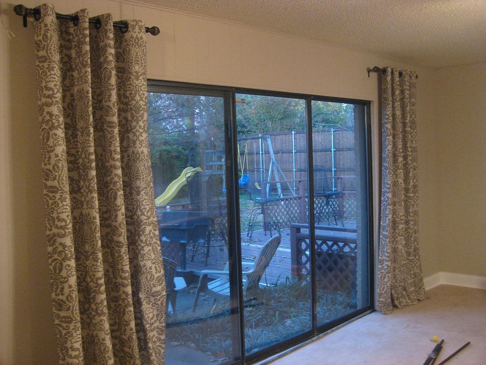 A living room with a sliding glass door and curtains