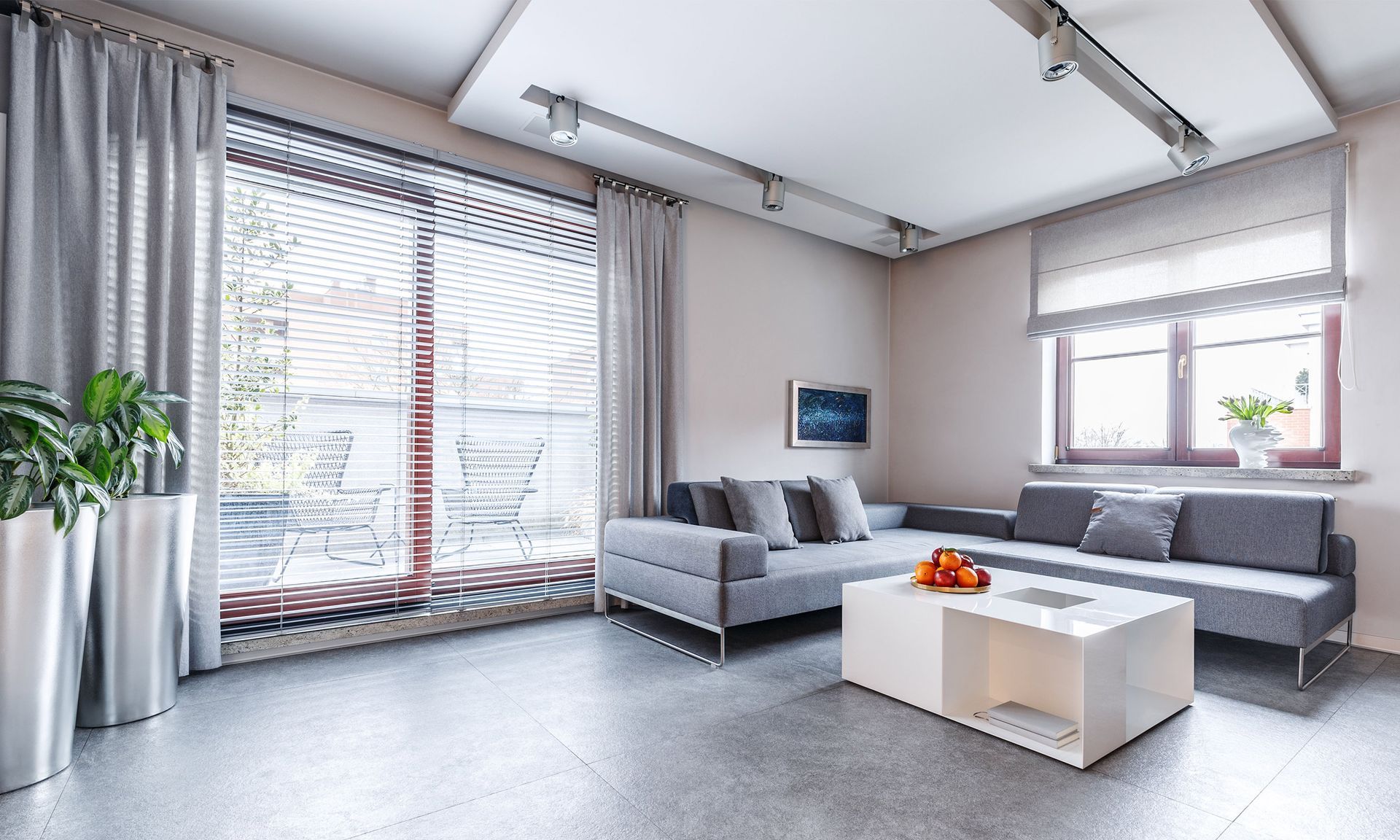 A living room with a couch , coffee table , and large windows.