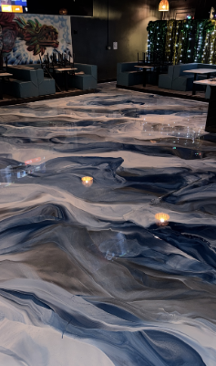 Abstract epoxy floor with blue, white, and gray swirls in a restaurant.