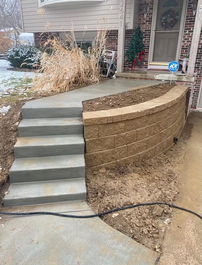 A set of stairs leading up to a brick wall in front of a house.