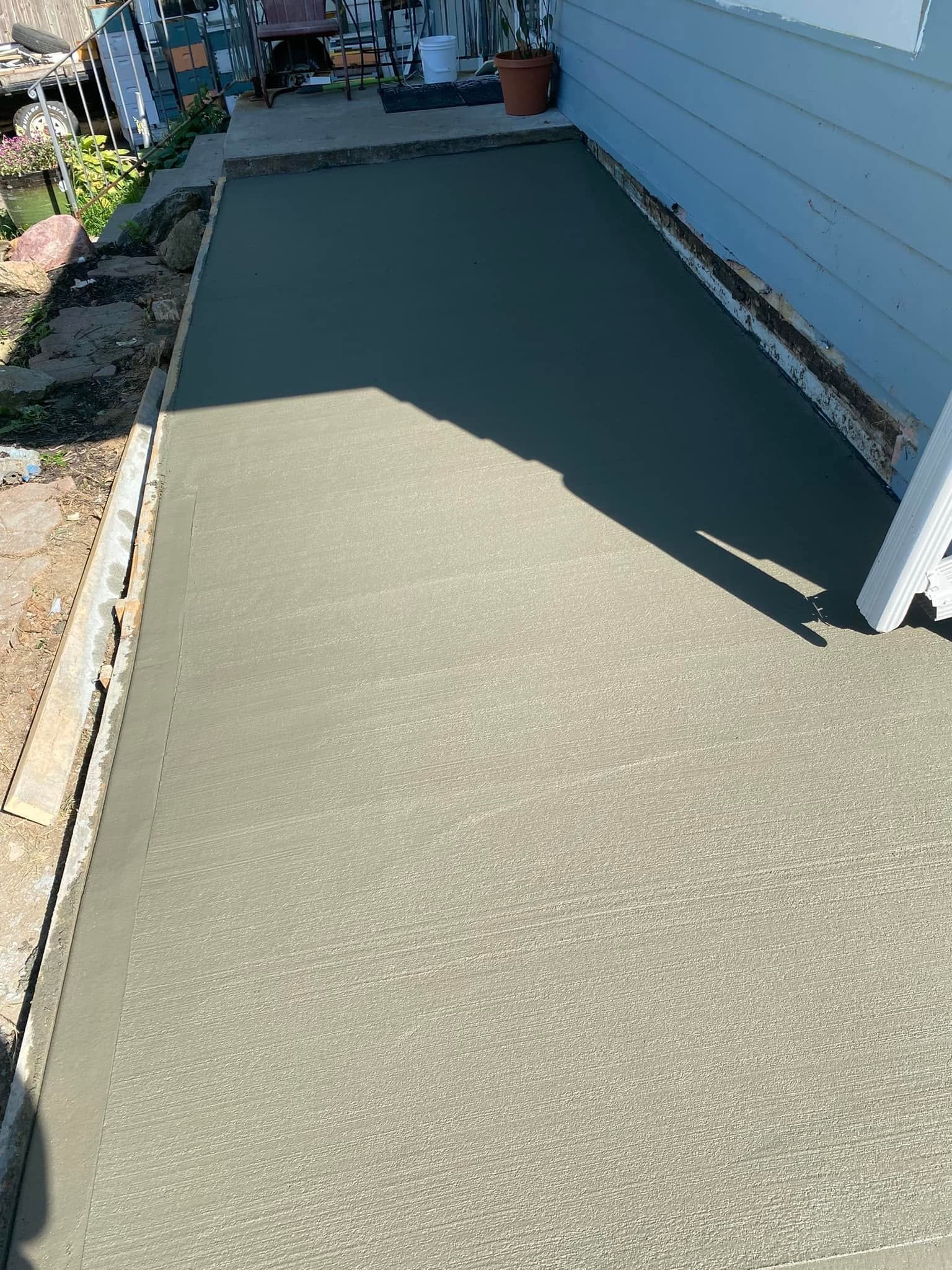 A concrete walkway is being built in front of a house.