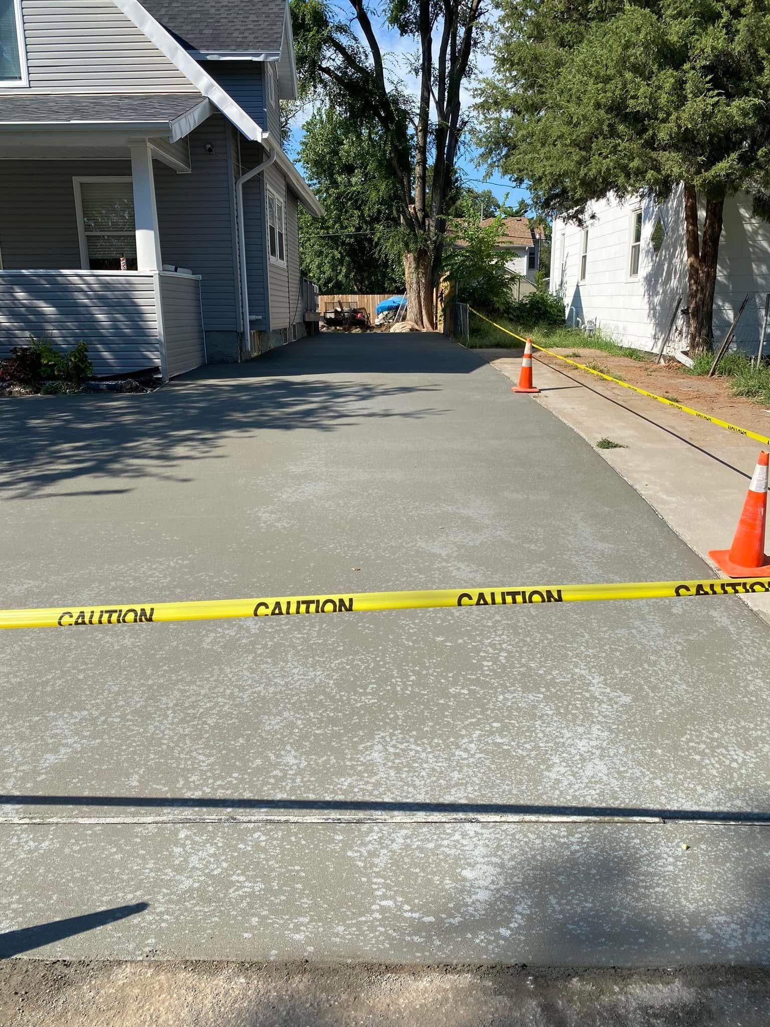 A concrete driveway is being built in front of a house.