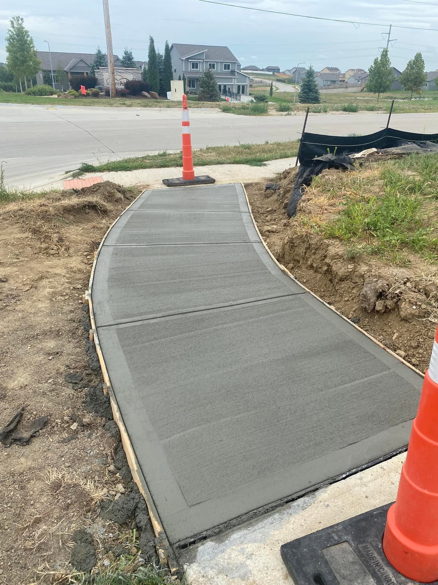A concrete walkway is being built next to a road.