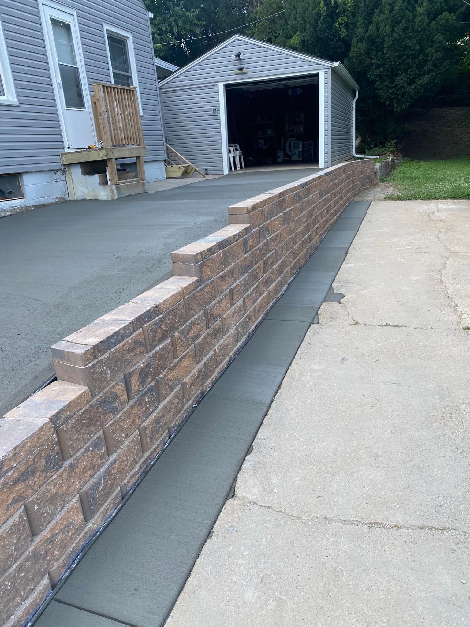 A brick wall is being built in front of a garage.