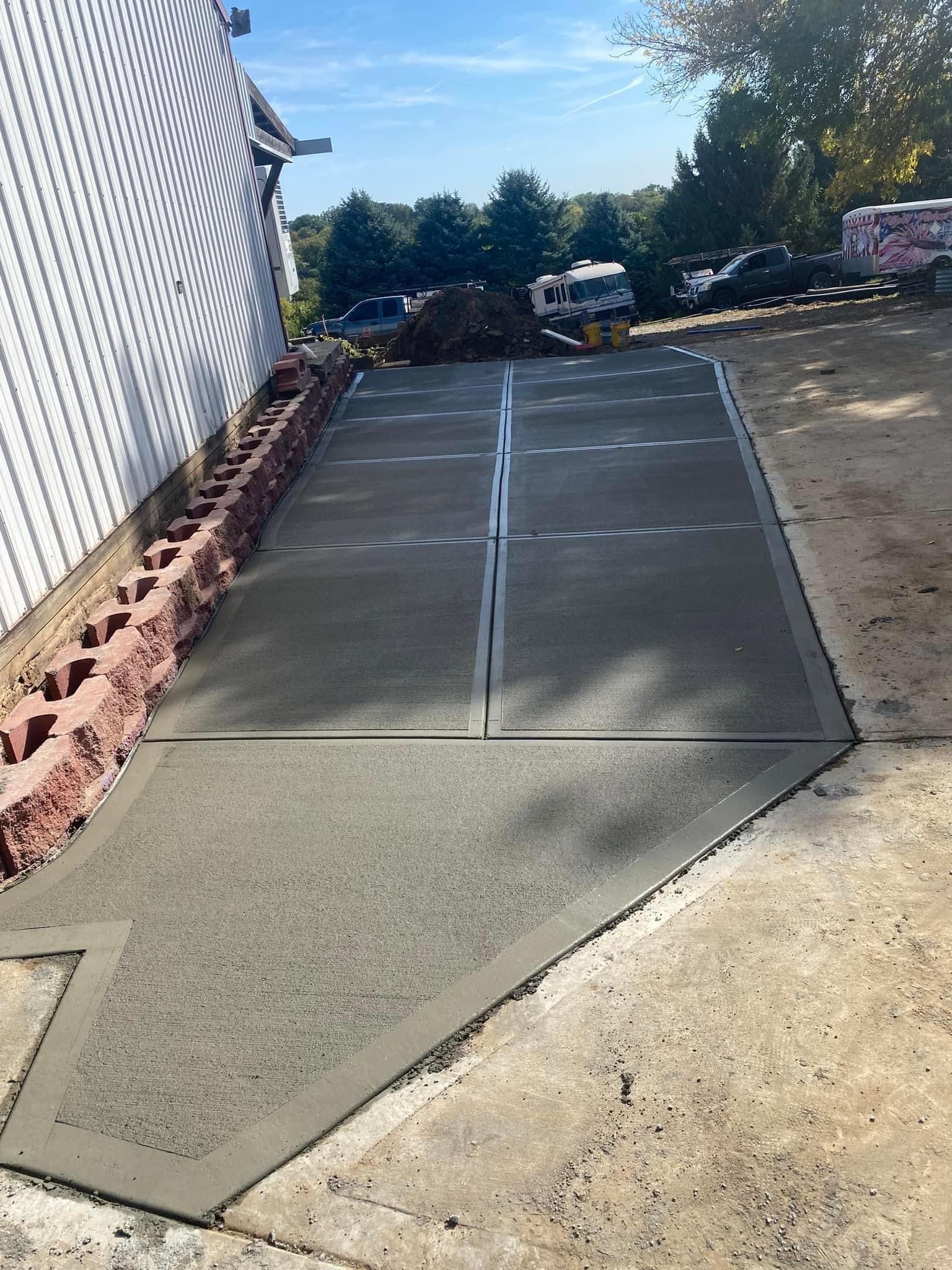 A concrete driveway is being built in front of a house.
