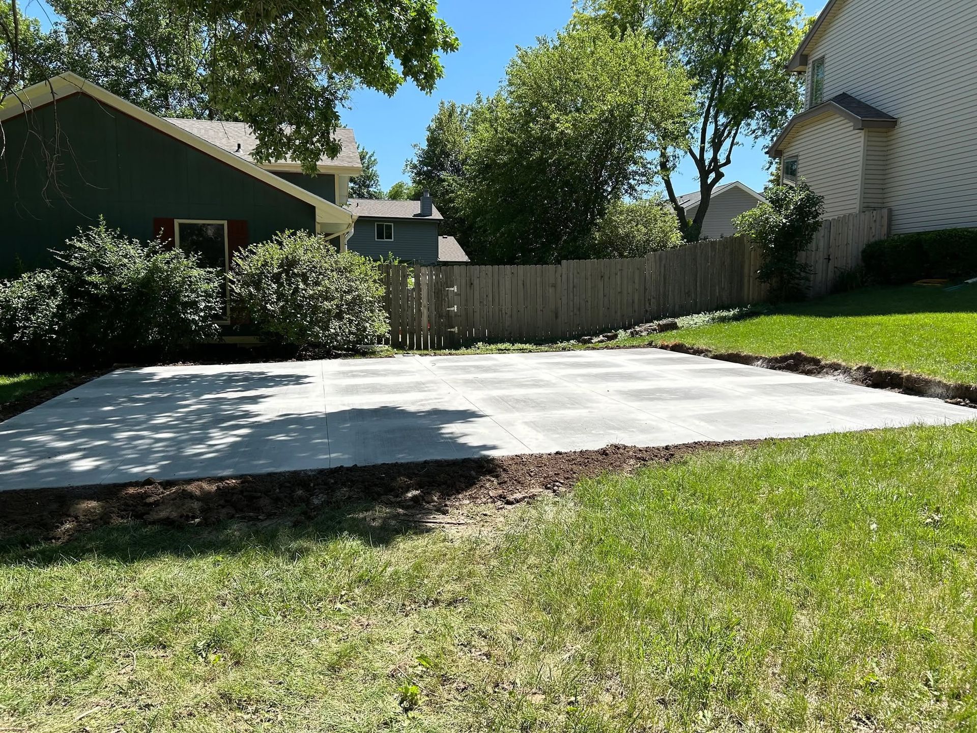 A concrete driveway in the backyard of a house