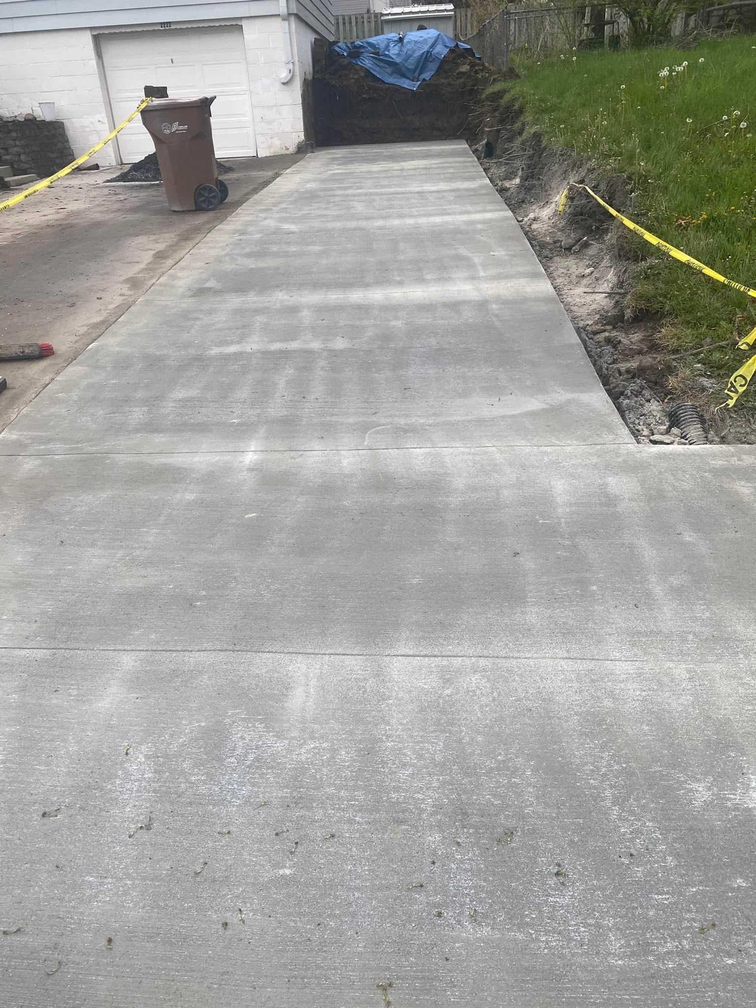 A concrete walkway is being built in front of a house.