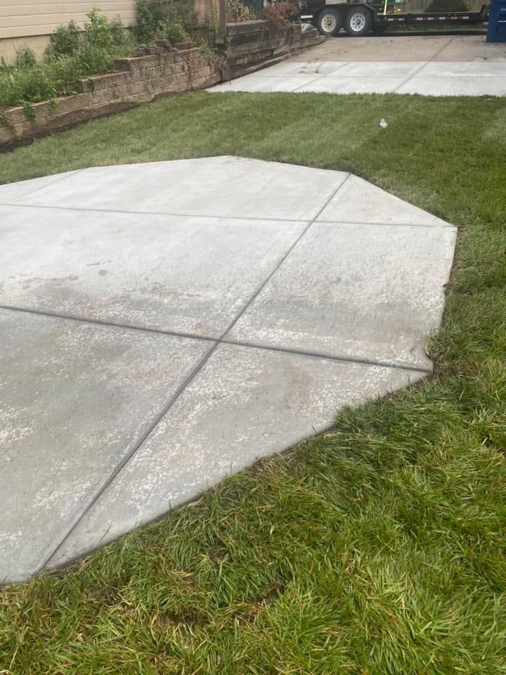 A concrete driveway with a truck parked in the background.