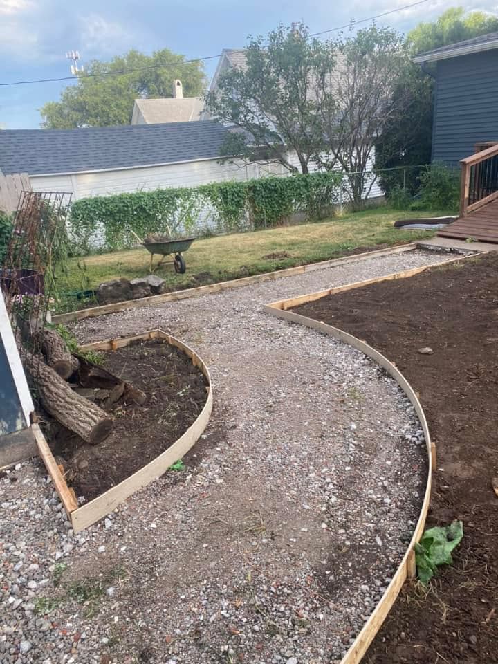 A concrete walkway is being built in a backyard.