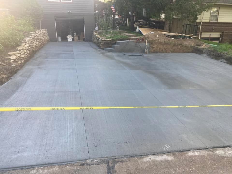 A concrete driveway is being built in front of a house.