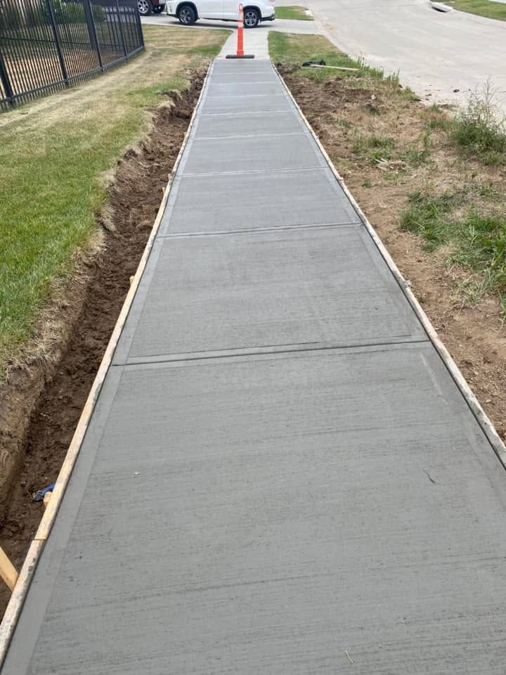 A concrete sidewalk is being built next to a road.
