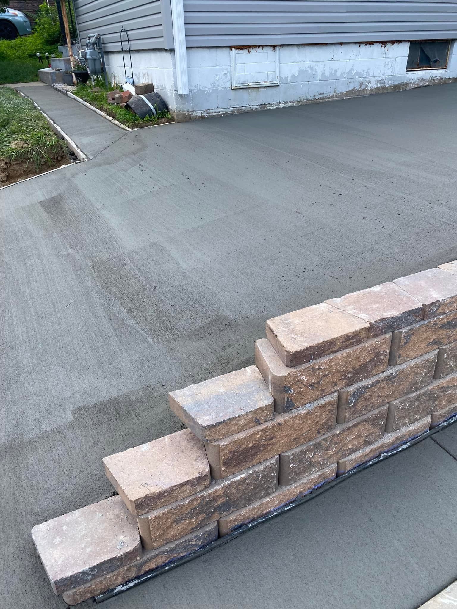 A brick wall is being built in front of a house.