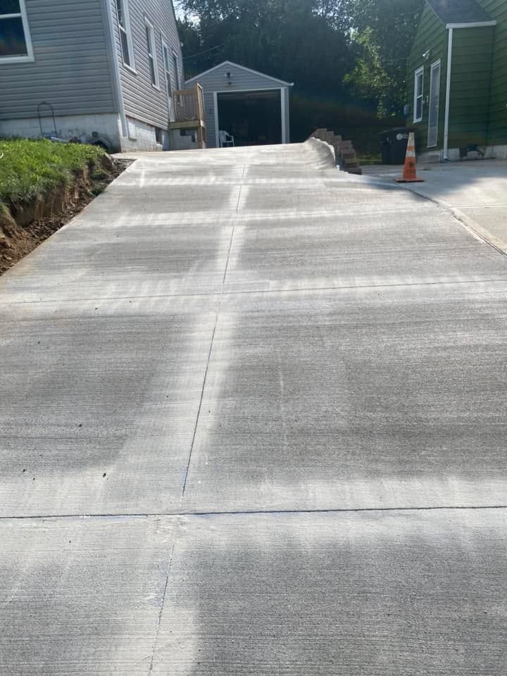 A concrete driveway is being built in front of a house.