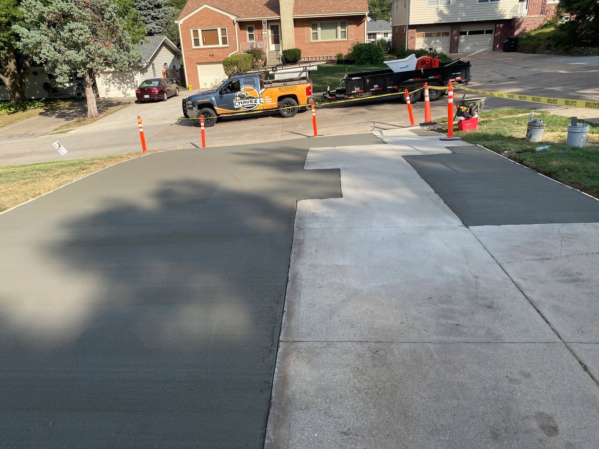A concrete driveway is being built in front of a house.