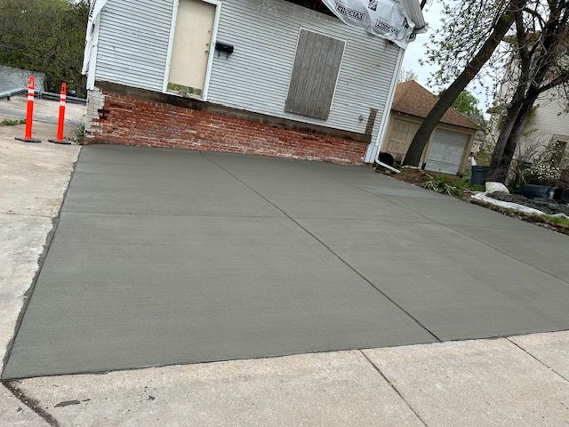 A concrete driveway is being built in front of a house.