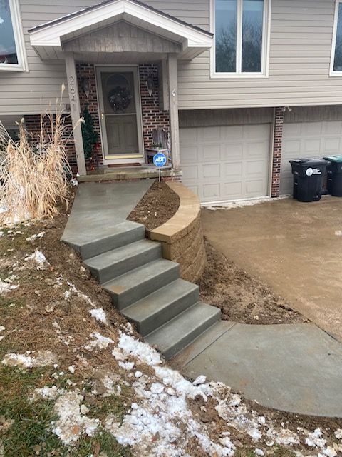 A concrete walkway leading to the front door of a house.