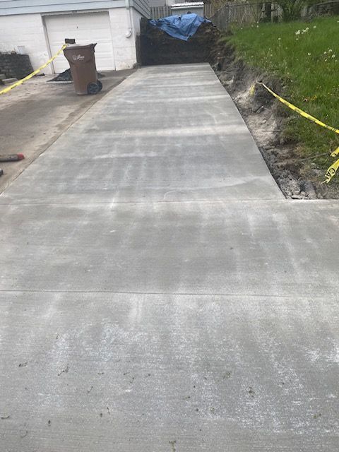 A concrete driveway is being built in front of a house.